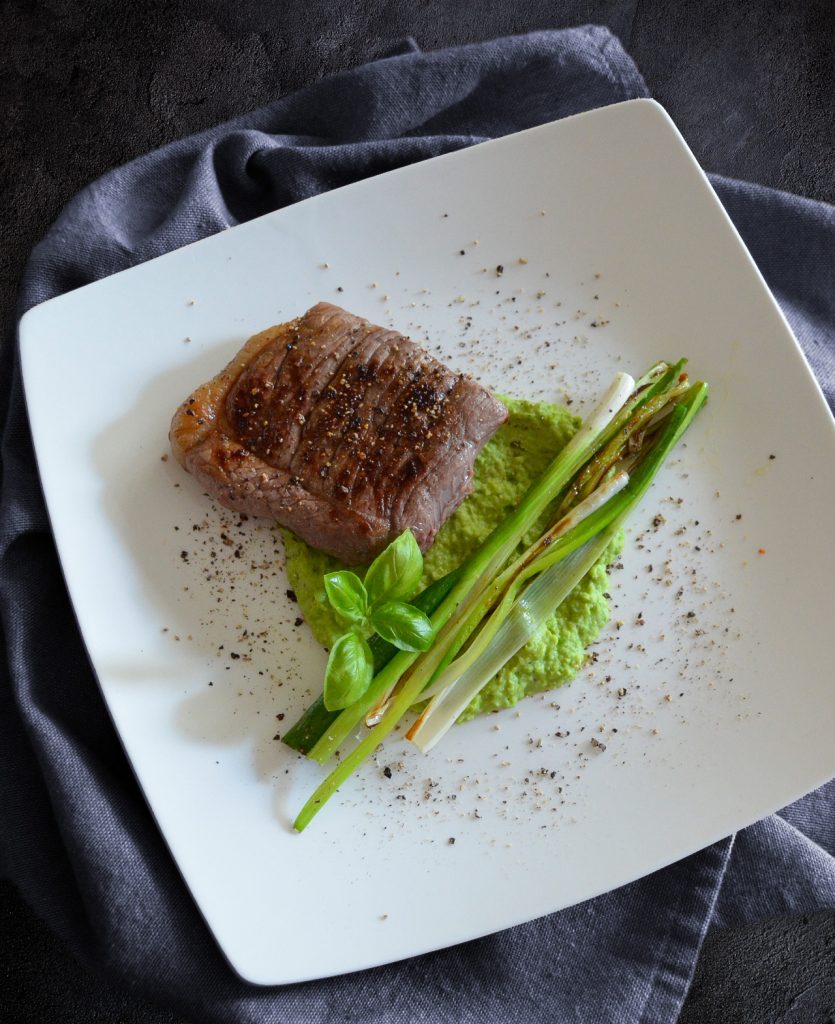 Kleines Steak auf Erbsenpüree mit gebratenen Lauchzwiebeln