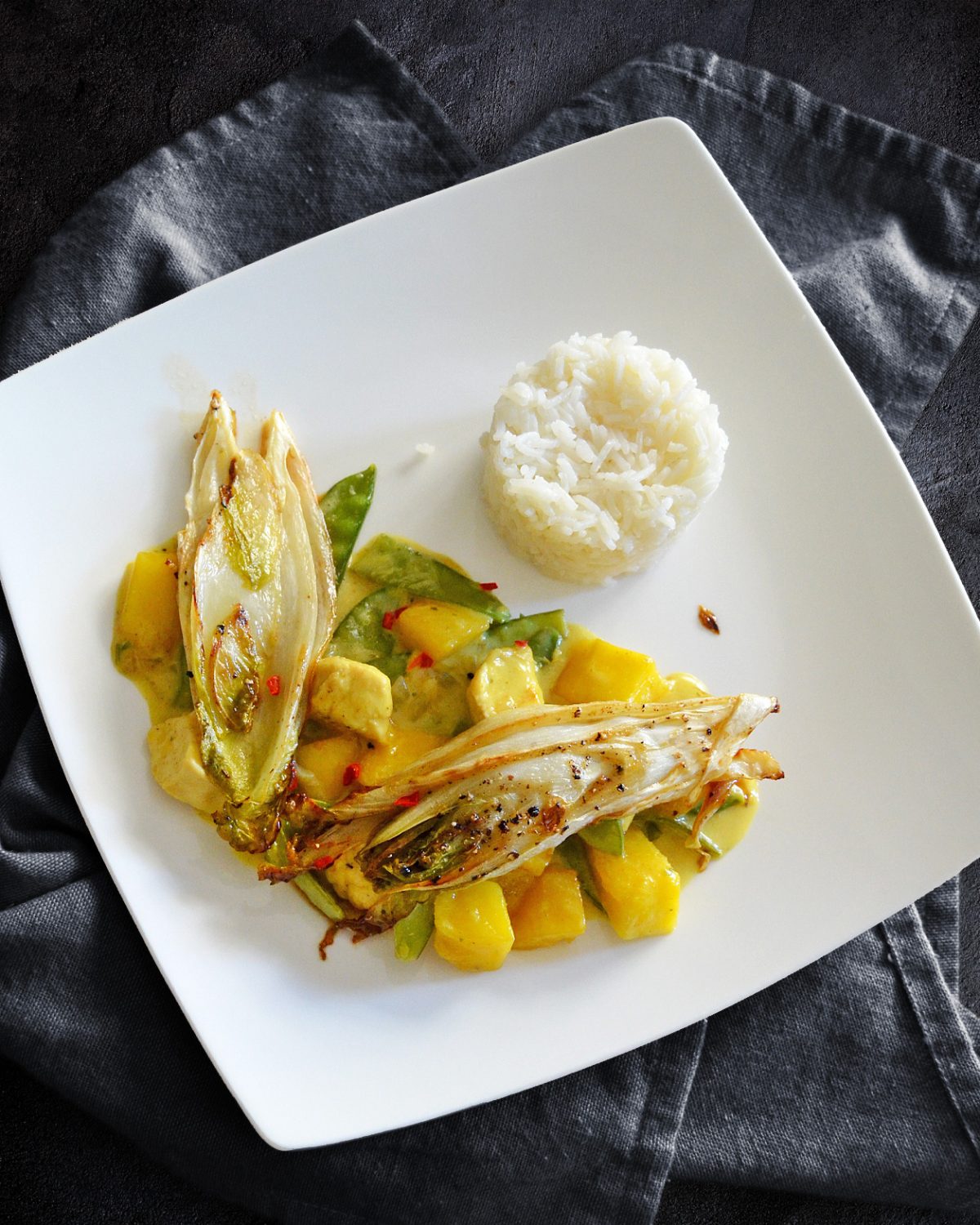 Hähnchencurry mit Mango, Zuckerschoten und karamellsiertem Chicorée