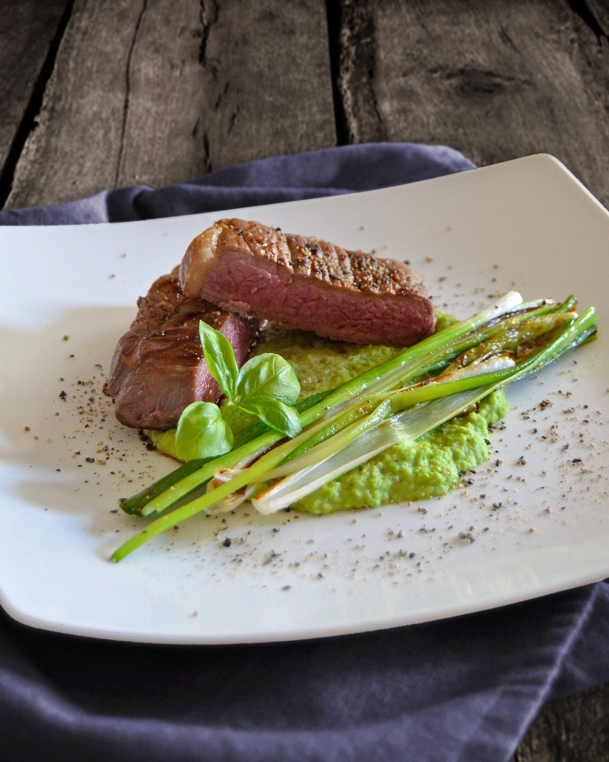 Kleines Steak auf Erbsenpüree mit gebratenen Lauchzwiebeln