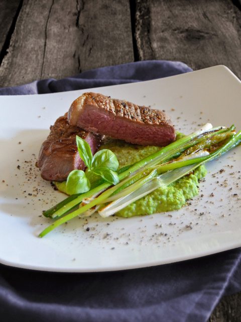 Kleines Steak auf Erbsenpüree mit gebratenen Lauchzwiebeln