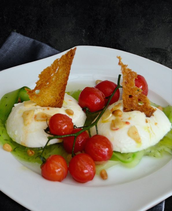 Mozzarella auf Gurkenstreifen mit geschmolzenen Tomaten und Knoblauch