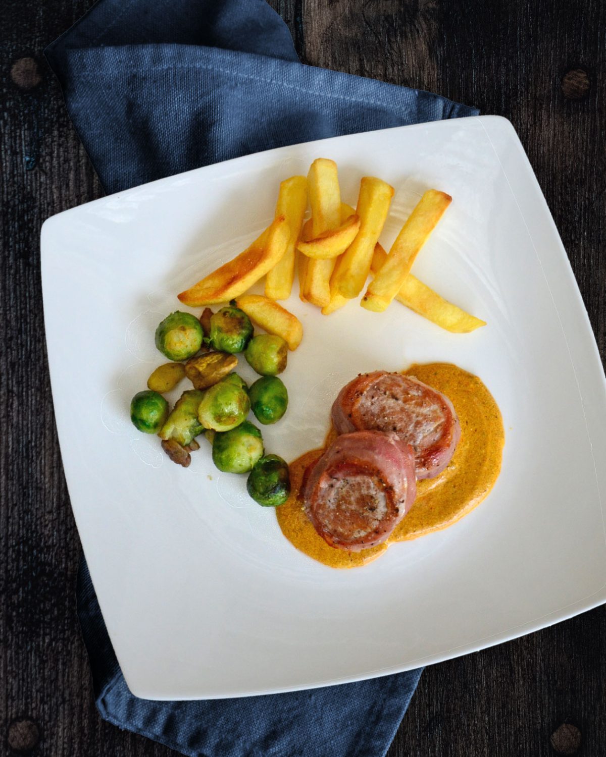 Schweinefilet-Medaillons im Schinkenmantel auf Currysoße