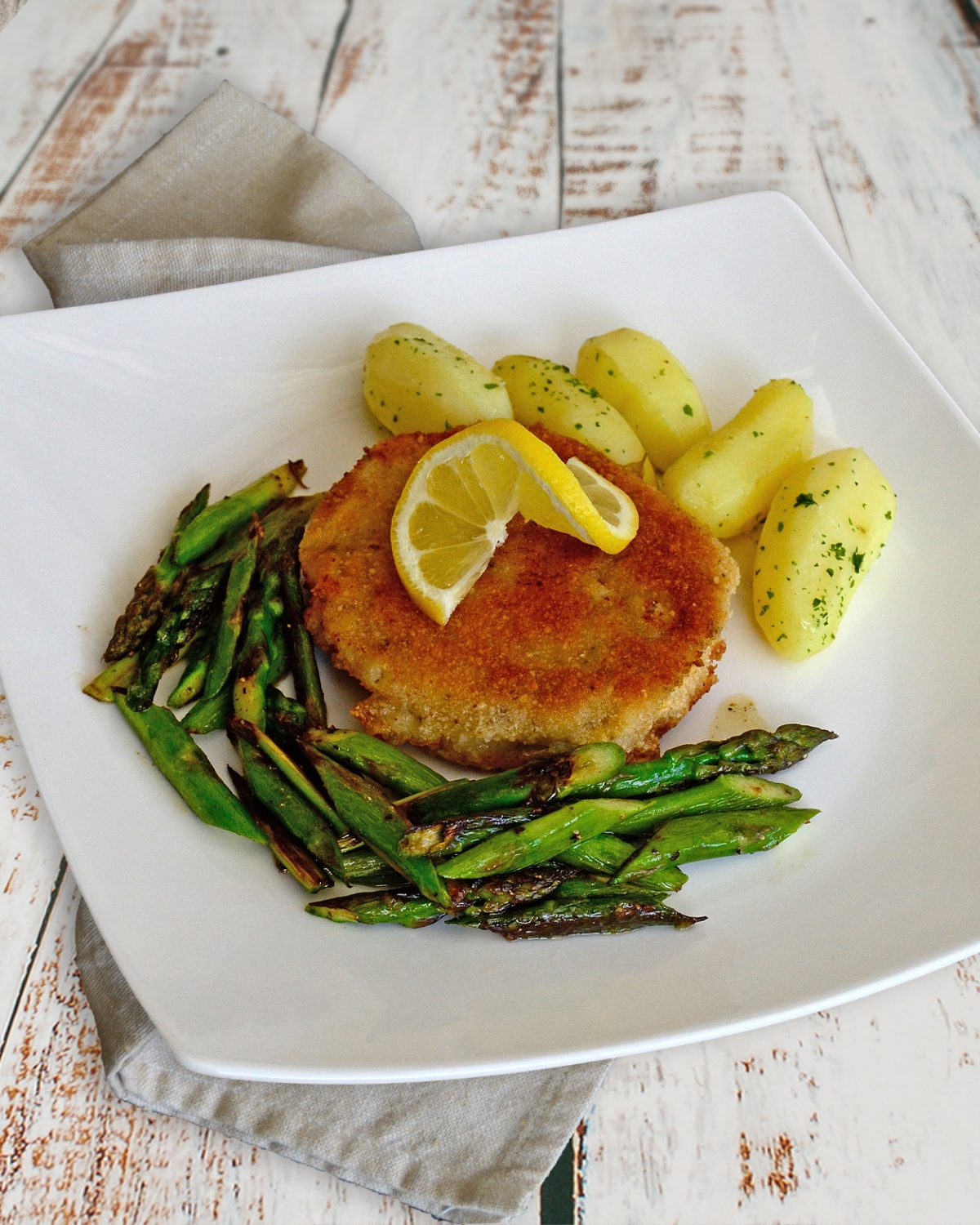 Paniertes Schnitzel mit grünem Spargel und Salzkartoffeln