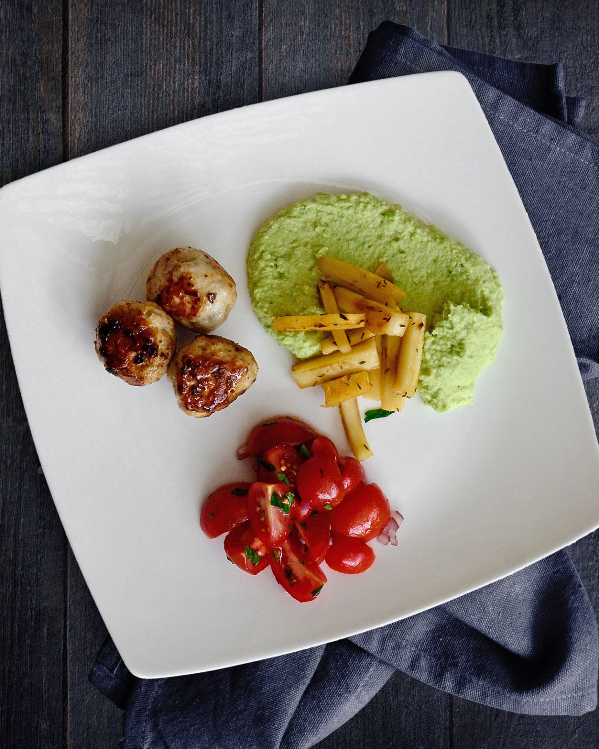 Gebratene Ptersilienwurzel auf Erbsenhummus mit Mini-Frikadellen und Tomatensalat