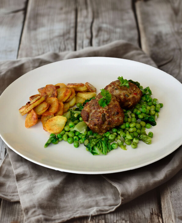 Frikadellen auf französischen Erbsen mit Bratkartoffeln