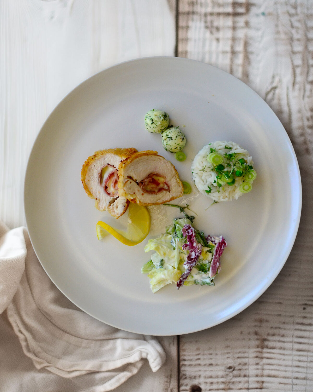 Hähnchen-Cordon bleu mit Erbsenreis, Kräuterbutter und Salat