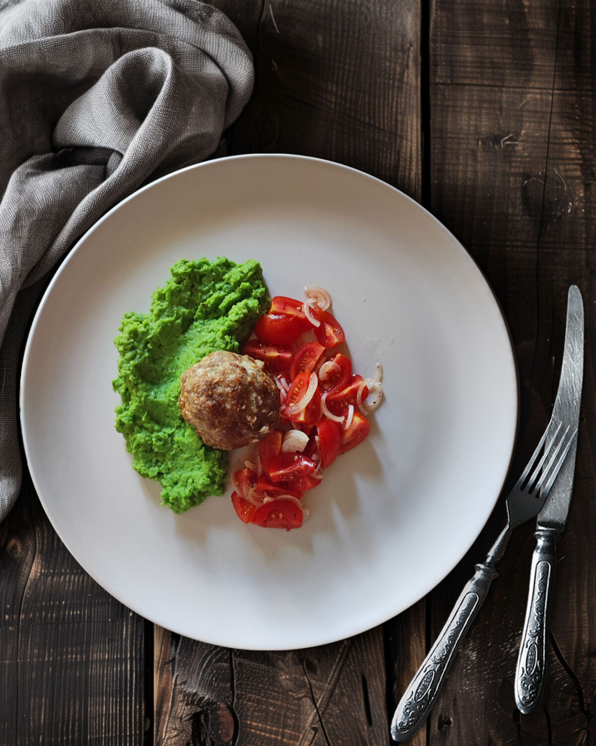 Bifteki auf Estragon-Erbsenstampf mit Tomatensalat