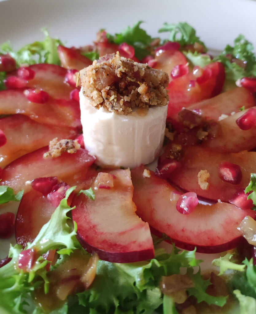 Ziegenkäsetaler mit Honig-Speck-Crumble auf Blattsalat mit Granatapfel-Dressing und Pflaumen-Carpaccio